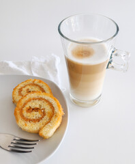 Latte macchiato coffee and swiss roll, roll cake over white background