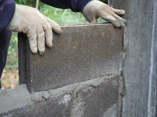 Industrial Construction bricklayer worker building walls with bricks, mortar. closeup photo, blurred.