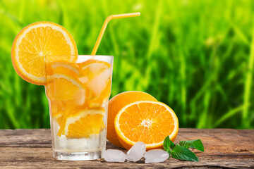 Natural lemonade with mint and fresh oranges on wooden table.