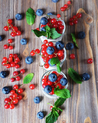 Healthy eating, food and diet concept. Yogurt with fresh berries in glass jar, on wooden background