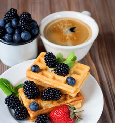 Good morning. Waffles with blueberries, strawberry and blackberries with a cup of coffee for breakfast