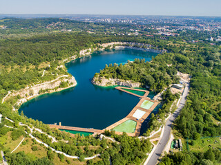 Krakow, Poland. Zakrzowek lake with steep cliffs in place of former flooded limestone quarry. Recreational place with swimming pools, restaurants and other facilities under construction. Aerial view