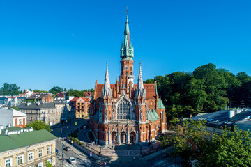 Fototapeta premium Krakow, Poland. Church Saint Joseph - a historic Roman Catholic church in Gothic Revival (neo-Gothic) style at the Podgorski Square in Podgorze district in Cracow in sunset light. Aerial view.