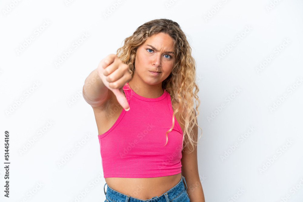 Wall mural Girl with curly hair isolated on white background showing thumb down with negative expression