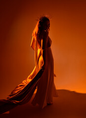 portrait of beautiful red-haired woman wearing long flowing fantasy toga gown with golden halo...