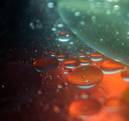 Abstract oil droplets in water reflecting the colors of a background to give a planet effect