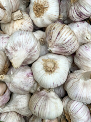 Garlic background. Cloves of fresh organic garlic on a farmers market. Full frame garlic. vegetable market, grocery shopping.