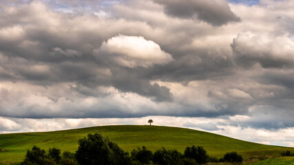 clouds over the hill with one tree