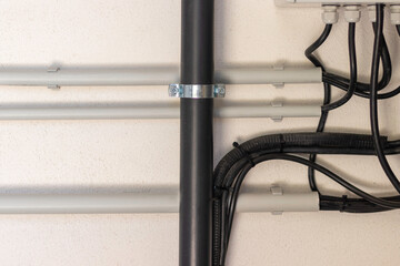 Close up view of electrical and plumbing instalation on white wall