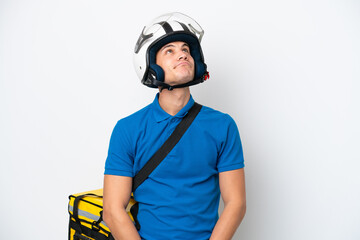 Young caucasian man with thermal backpack isolated on white background and looking up