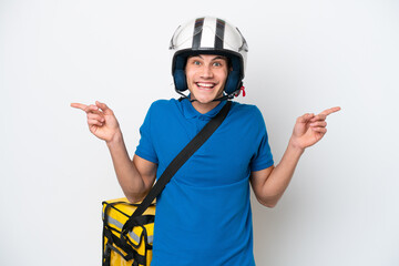Young caucasian man with thermal backpack isolated on white background pointing finger to the laterals and happy