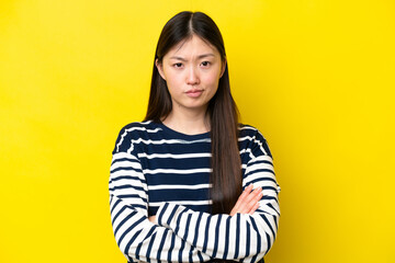 Young Chinese woman isolated on yellow background with unhappy expression