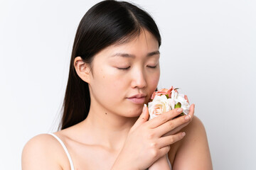 Young Chinese woman isolated on white background holding flowers. Close up portrait