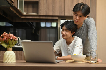 Happy gay couple spending the day together with the movie on the laptop, Gay couples and Everyday life at home concept.