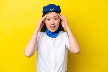 Airplane Chinese woman stewardess isolated on yellow background with surprise expression