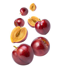 Red cherry plum fruit and cut in half sliced flying in the air isolated on white background. 