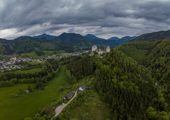 Aerial drone view of castle Gallenstein, close to Sankt Gallen in Austria on a cloudy summer day. Green forest surrounding the ruins of a castle.