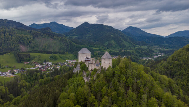 Aerial drone view of castle Gallenstein, close to Sankt Gallen in Austria on a cloudy summer day. Green forest surrounding the ruins of a castle.