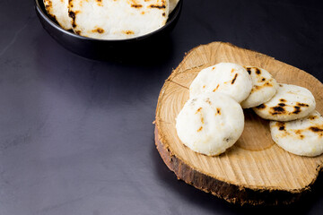corn arepa traditional colombian food on wooden log