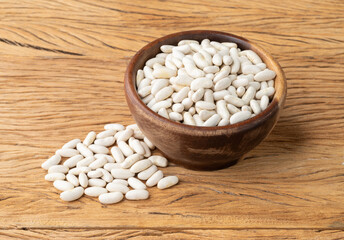 White beans in a bowl over wooden table