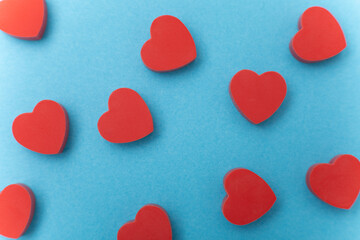  Small red hearts on a blue background. Background love symbol . Flat lay