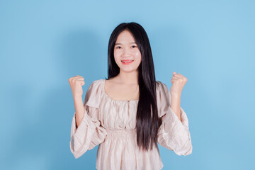 Crazy happy woman sincerely rejoices in her success and triumph on blue background