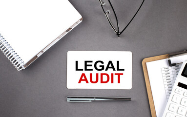 LEGAL AUDIT text written on the card with notebook and clipboard, grey background