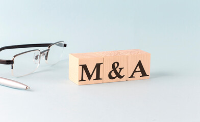 Text M and A - written on the wooden cubes on blue background