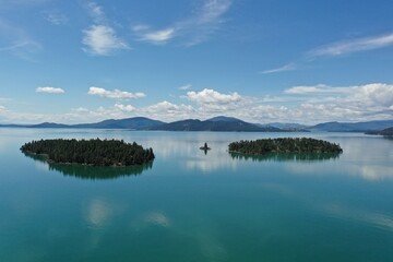 Aerial view of islands and distant mountains in Flathead Lake, Montana on calm summer morning.