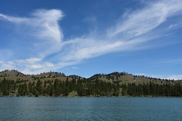 Beautiful dramatic summer cloudscape over Flathead Lake in Montana on calm June day.
