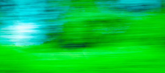 Abstract Green trees blue sky motion blurred green leaves background.Banner.