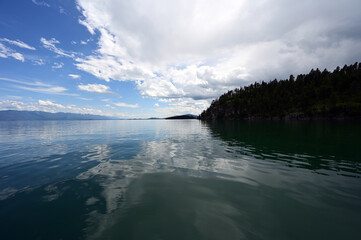 Beautiful dramatic summer cloudscape over Flathead Lake in Montana on calm June day.
