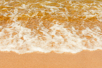 Soft beautiful sea wave on sandy beach. Water bright background.Top view.Copy space.