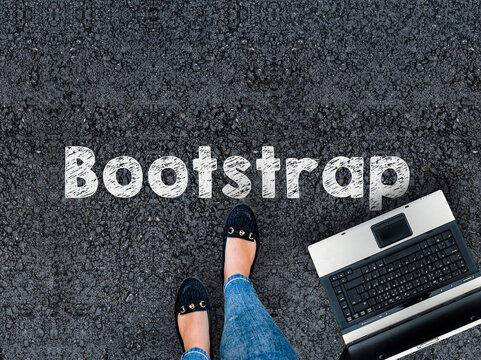 Bootstrap CSS framework . .A woman steps to a laptop and Bootstrap word on asphalt road
