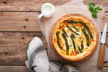 Quiche. Homemade asparagus pie or quiche with cheese and spinach on old wooden table background. Asparagus and cheese tart. French Quiche. Top view.