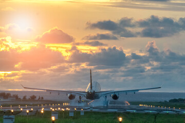 Fototapeta na wymiar Plane is flying to the airport sunrise. 