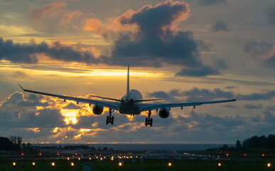 Fototapeta premium Plane is flying to the airport sunrise. 