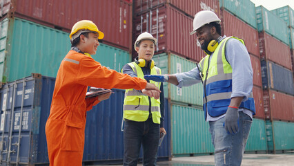 A group of three engineers join hands together with a smile.