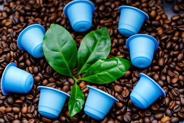 Blätter einer Kaffeepflanze und geröstete Kaffeebohnen - obrazy, fototapety, plakaty