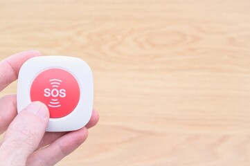 person holding a red SOS button - emergency and danger situation concept