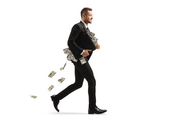 Full length profile shot of a businessman running with a briefcase full of money