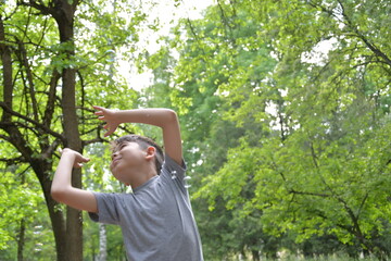 Child catches soap bubbles in the park in summer
