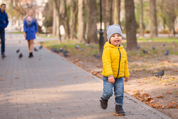 A little boy runs along the path in the park.