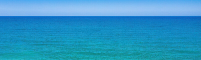 Seascape minimal panoramic background. Clear sky, horizon over blue waves