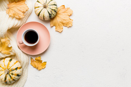 Flat lay composition with colorful Autumn cup of coffee and leaves on a color background. top view