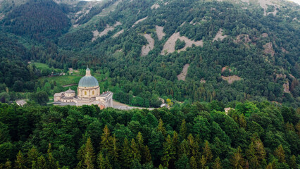 Fototapeta na wymiar Aerial view of The Sanctuary of Oropa, Roman Catholic building in the Biellese Alps, Northern Italy. Tourist attraction and famous place of pilgrimage in Piedmont. Drone photography.