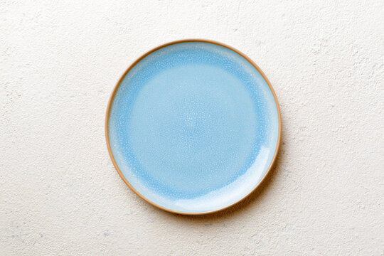Top view of empty blue plate on cement background. Empty space for your design