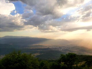 Sunset over the Sarajevo valley and mountains around, sun rays breaking through clouds, Bosnia and Herzegovina