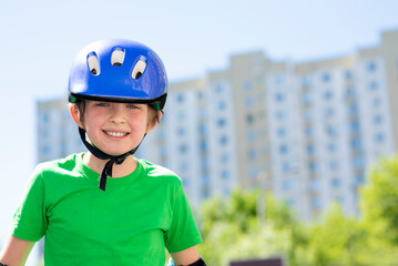 happy smiling boy in sports helmet doing active sport in summer