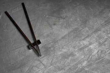 Pair of lacquered chopsticks on textured background